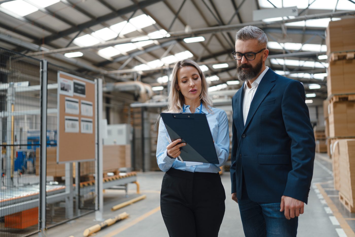 Two managers reviewing performance on the factory floor