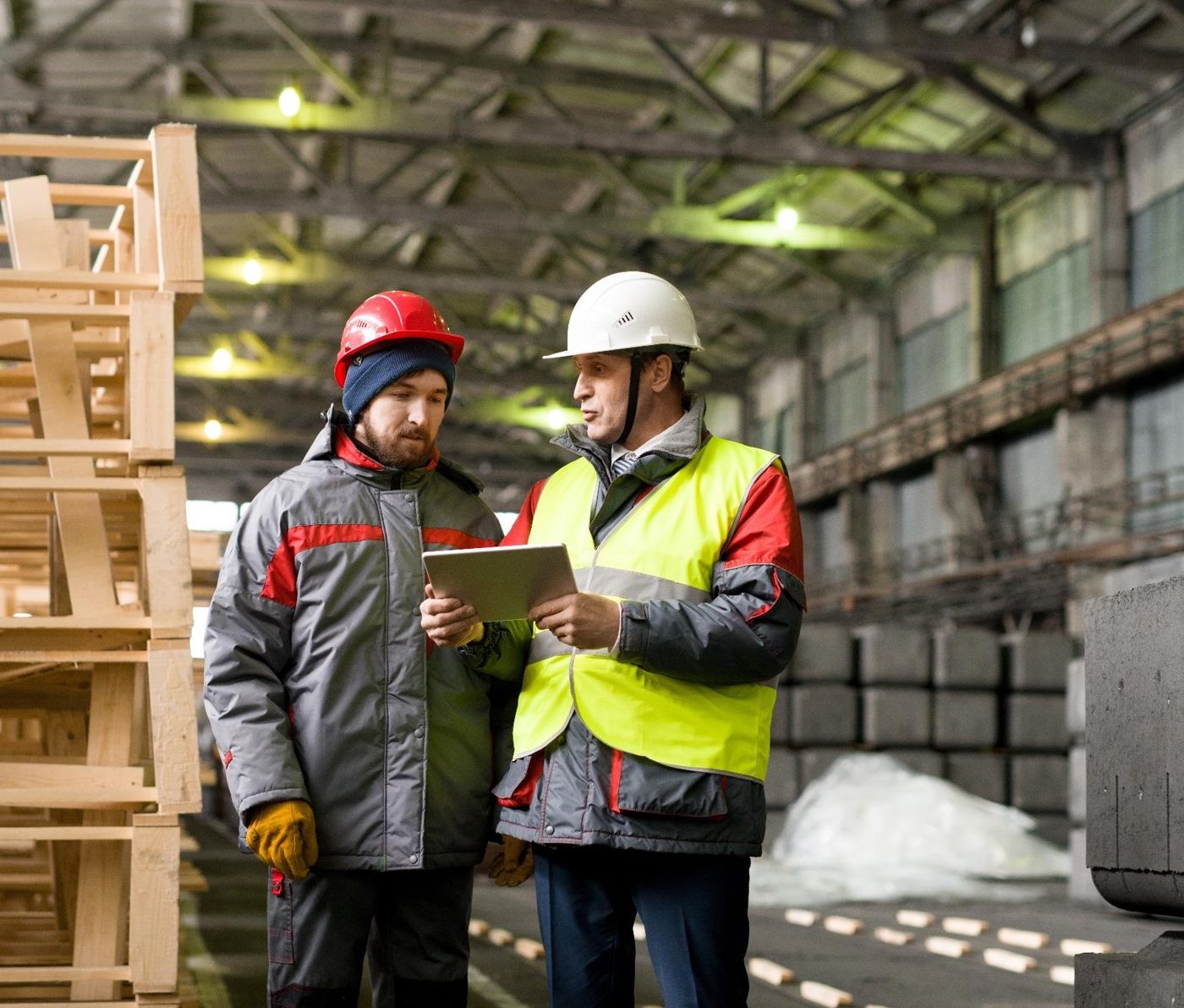 Two operators reviewing a digital checklist on a tablet in a warehouse